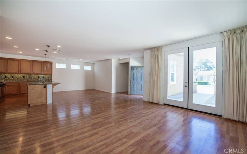 Living room looking towards the front door, dining room and kitchen. Beautiful wood like laminate floors throughout.