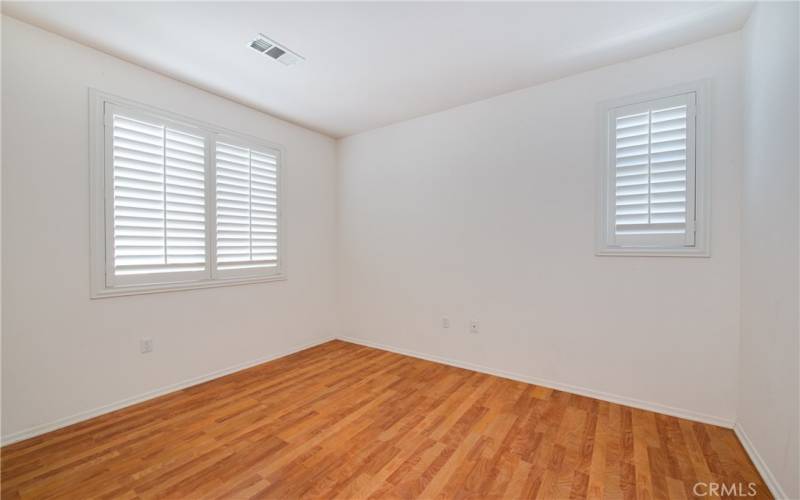 Generous sized guest bedroom with mirrored closet doors.