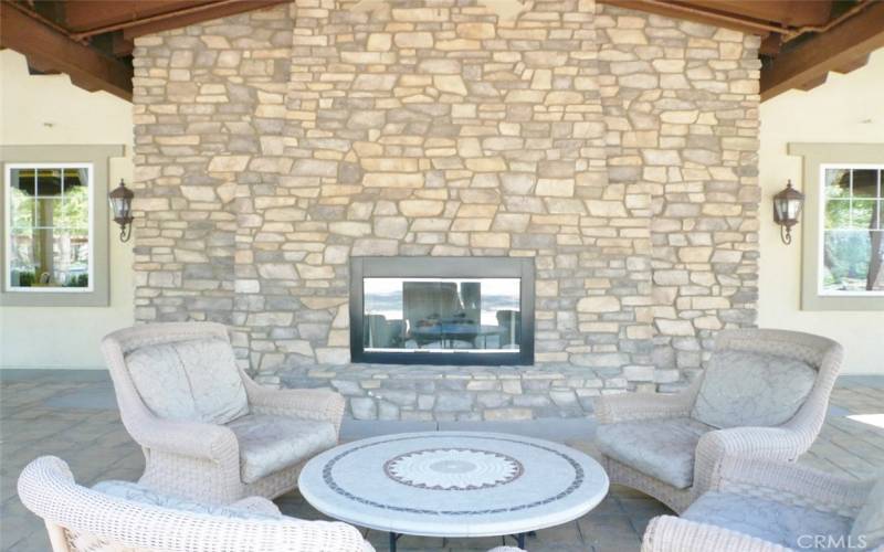 Outdoor dining and lounge area with flagstone fireplace.