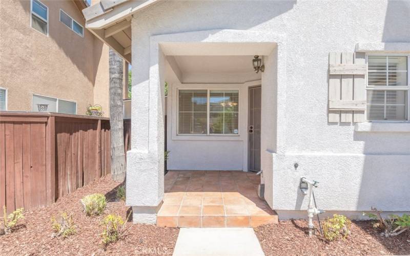 Cozy porch with tile flooring and fresh landscaping