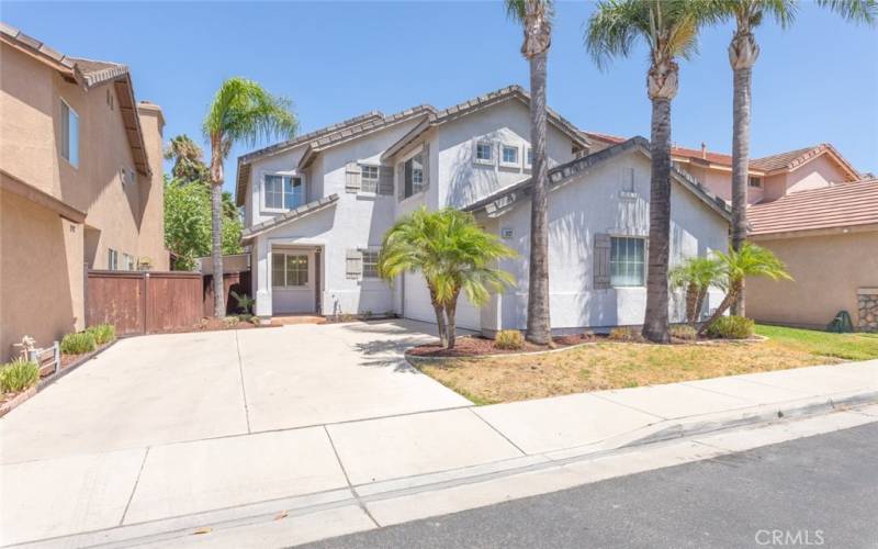 This charming home boasts excellent curb appeal with its clean, modern exterior, vibrant landscaping, and towering palm trees creating a welcoming and stylish entrance.