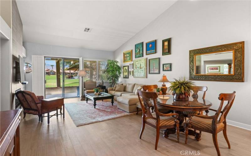 Living room with vaulted ceilings, fireplace and slider to patio and golf course.