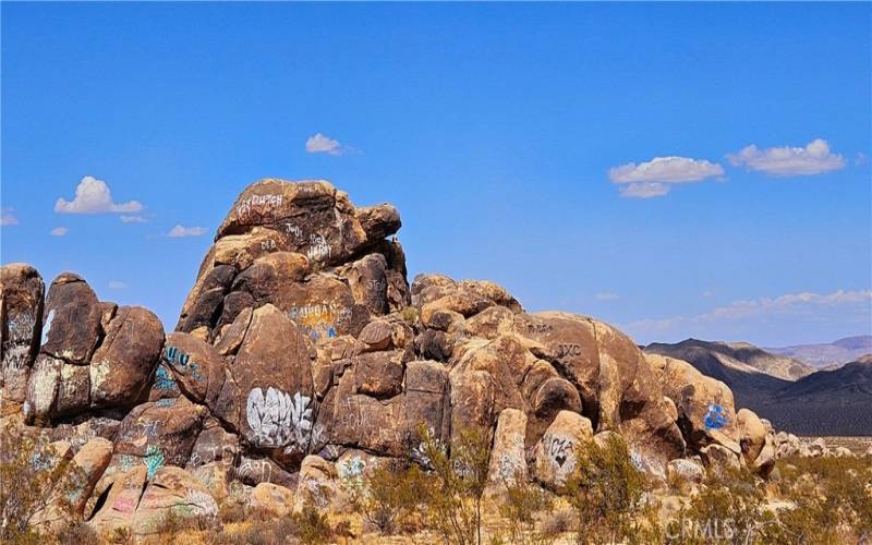 Graffiti rocks are not at the subject property. This view is alongside paved Old Woman Springs Rd. on the way to the property.