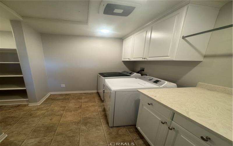 large Laundry room with sink and build in shelves.