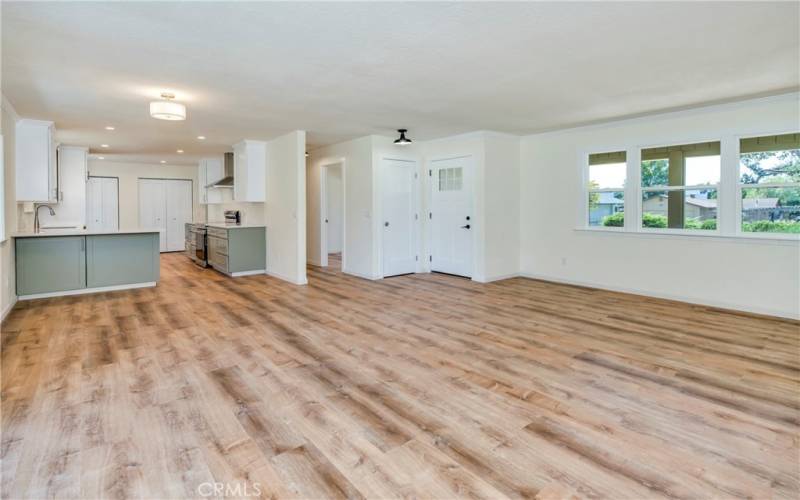 Open great room with large picture windows looking to the front and slider leading to back deck