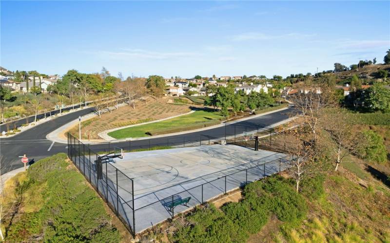 Community basketball court with a park across the street