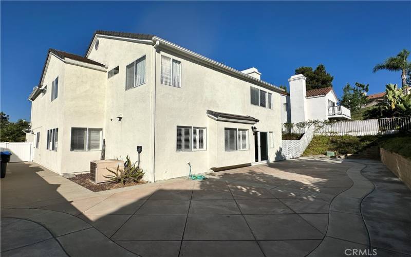 Back of the home with a wrap around stamped cement patio, low maintenance.