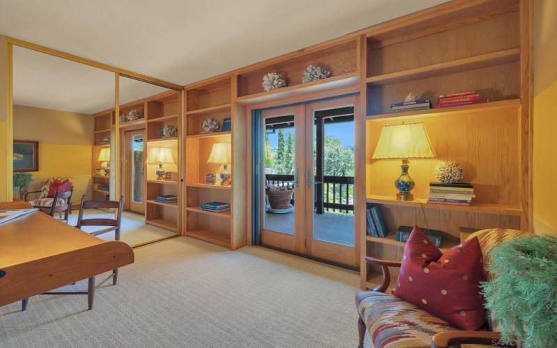 The second bedroom includes a full-size Murphy bed, desk hutch combination, large closet with built in shelving, French doors onto the screened in deck.