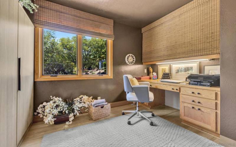 The first bedroom is furnished as a home office and includes hutch and storage armoire.