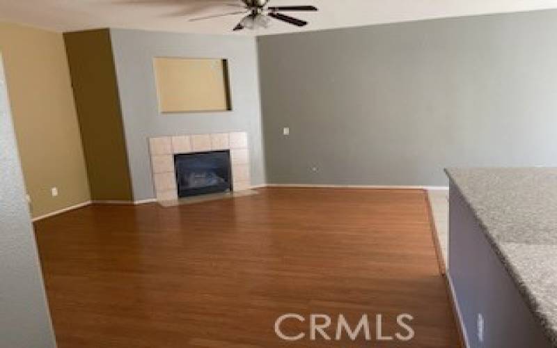 Family room with fireplace by kitchen in 14615 Tucson St, Victorville CA 92394