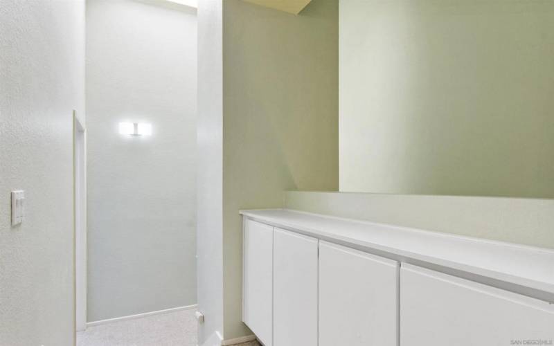 Upstairs hallway with vaulted ceilings, skylight and built-in cabinetry