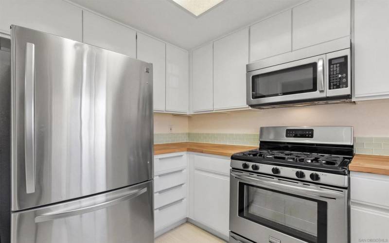 Stainless steel appliances and butcher block looking counters