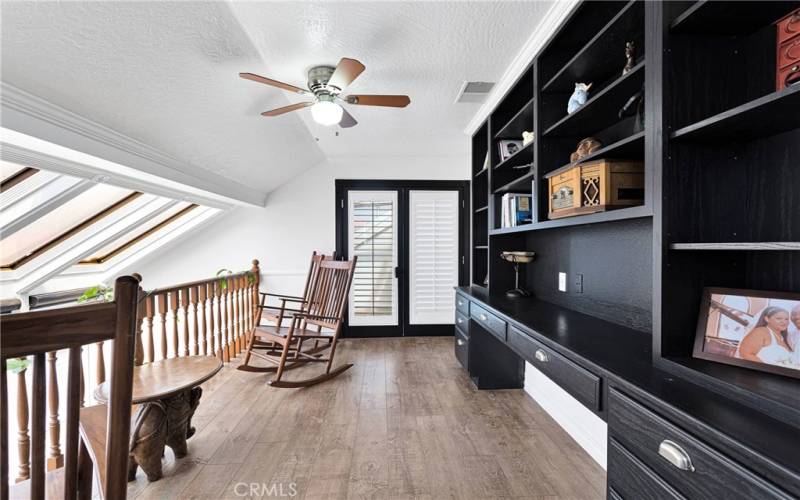 Loft area with built in bookshelves and patio