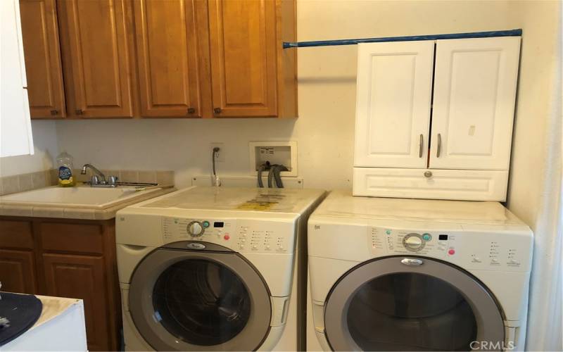 Laundry room has a sink and a space for freezer or extra refrigerator.