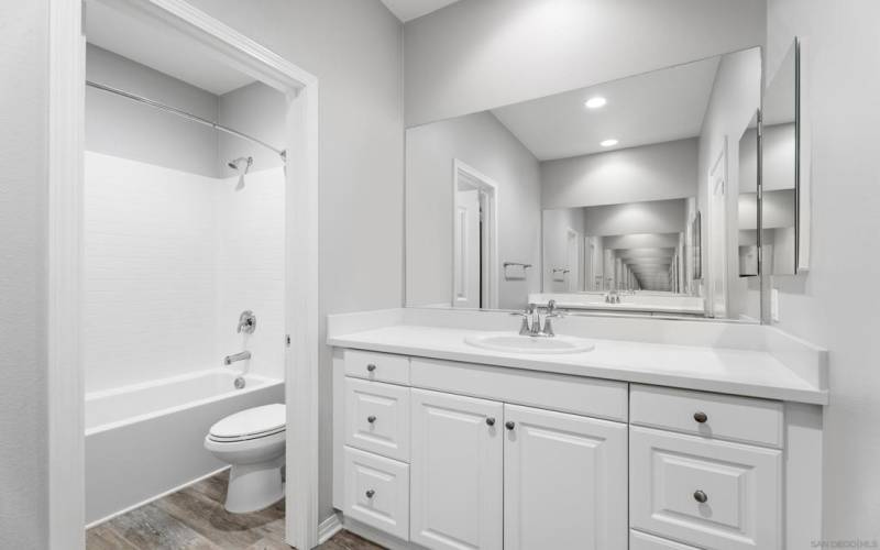 Bathroom with dual vanities and tub / shower combo to service both upstairs guest rooms