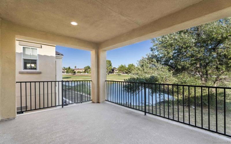 Balcony off primary bedroom ~ generous space and serene views of pond and golf course fairway