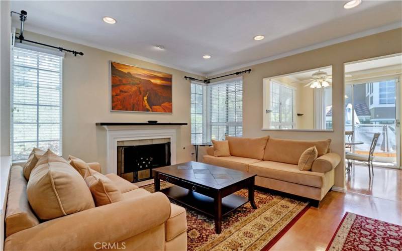 Furnished living room with decorative fireplace, recessed lighting, and view of hillside