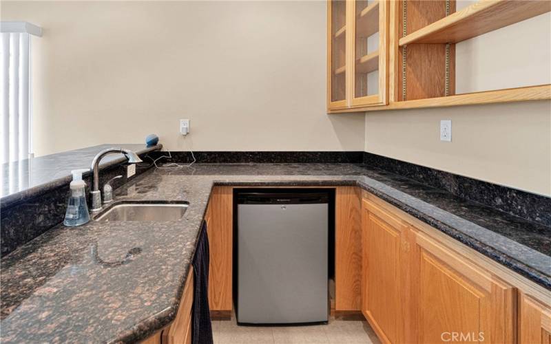 Fully functional wet bar with fridge, adjustable bar ware display, and lots of counter space.