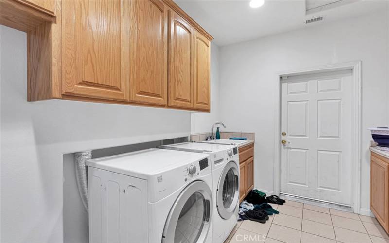 Spacious laundry room with an abundance of cabinets.