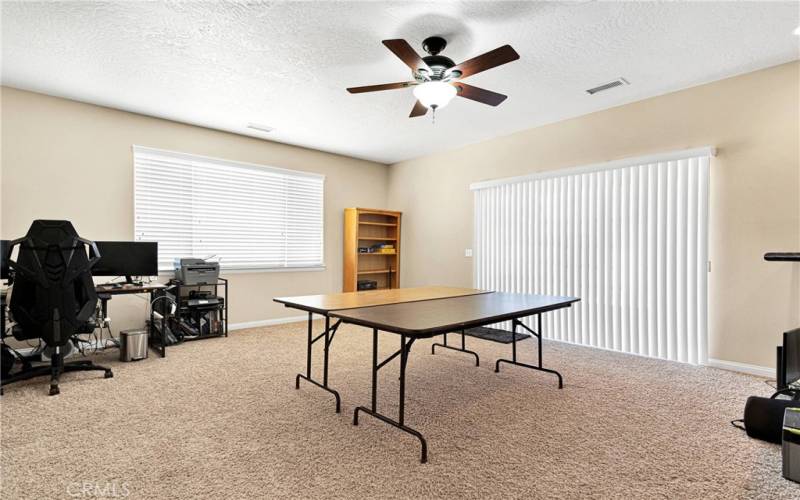 For scale, these are two banquet tables set in this enormous bonus room. This room outfitted with patio door to full span covered patio, and a large wet bar. Adjacent to this room is a. Bathroom with a shower.