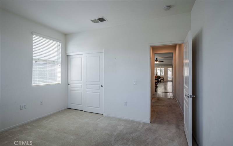 Second bedroom, past the blue bathroom and hallway cupboards with closet looks onto the front yard and golf course accross the street.