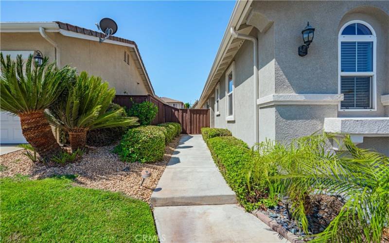 Front concrete walkway leads to your front door nicely trimmed with greenery.