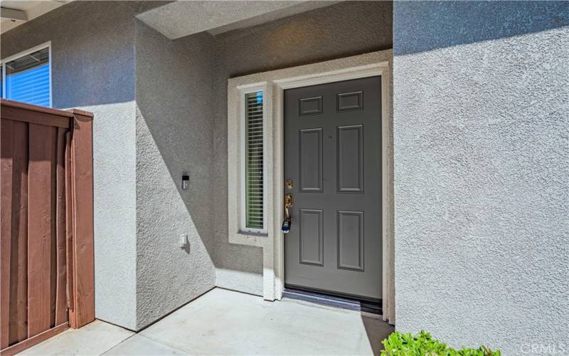 Front door has a window next to it, and the wood gate to the left opens to the back yard.