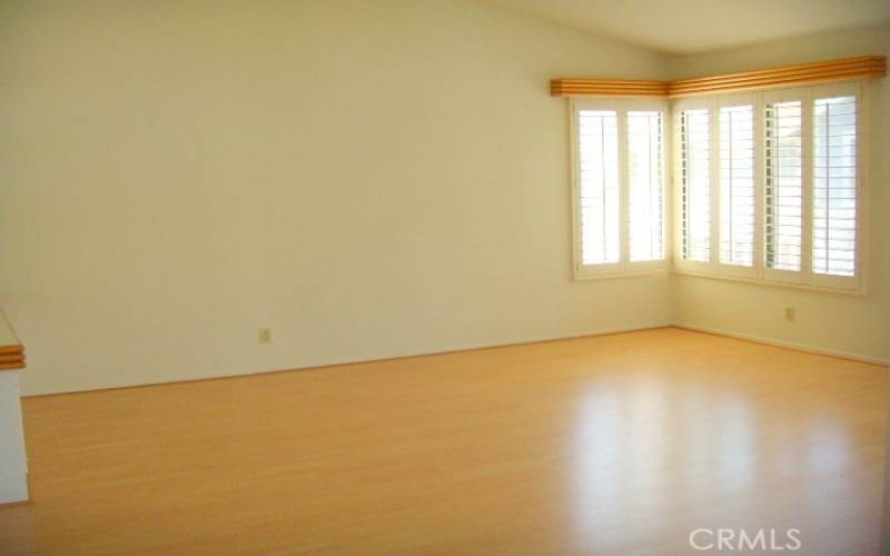 Spaciious living room with laminate flooring and plantation shutters