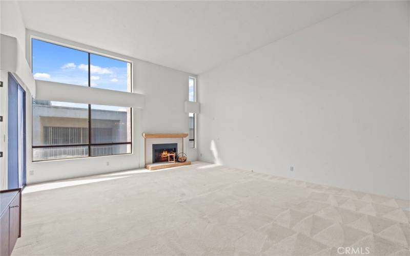 Living room with high ceilings, fireplace, flooded with light