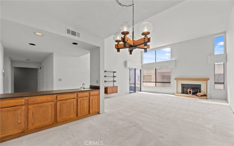 Dining room, wet bar with lots of cabinets, living room with fireplace, large patio/deck access, flooded with light.