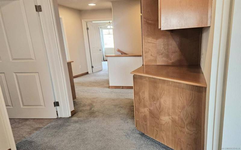 Upstairs storage cupboards are conveniently located outside laundry room.