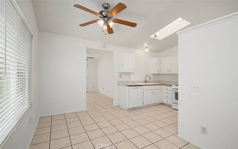 Dining with a ceiling fan and Kitchen Skylight