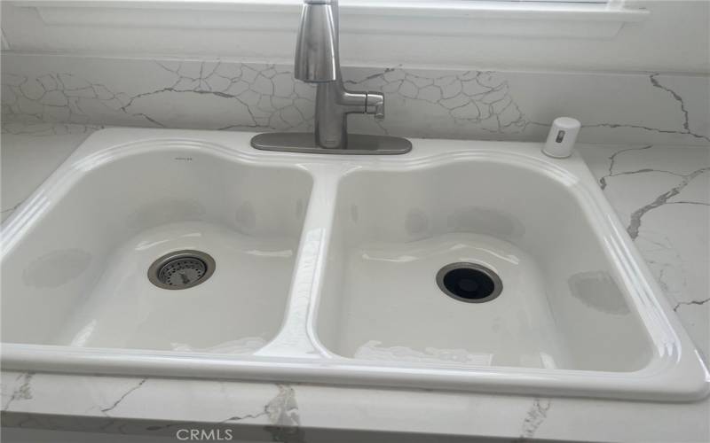 Pretty double sink, new faucet and garbage disposal.