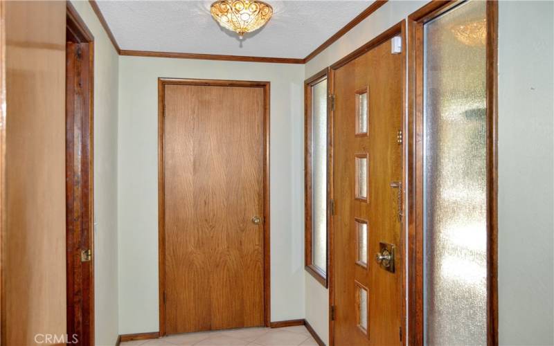 A small, tiled entry welcomes guests and offers a handy coat closet right where it should be