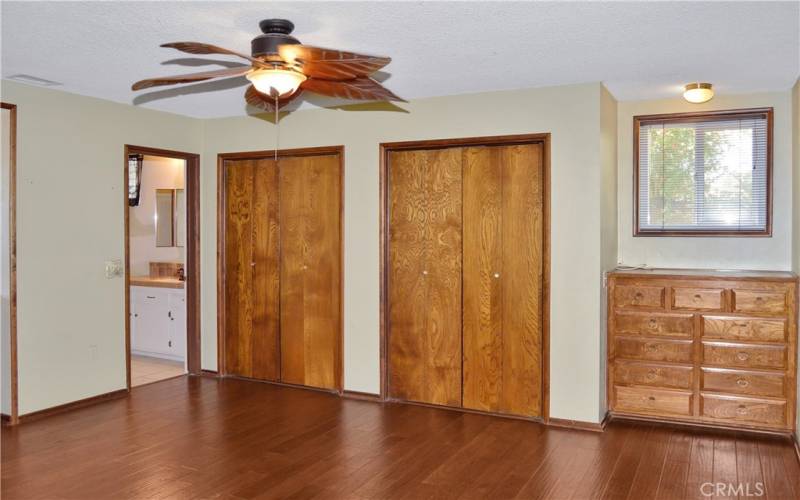 The main bedroom suite offers two built-in dressers, dual closets, access to the backyard covered patio, more gorgeous wood floors, and an ensuite bath we'll re-visit later.