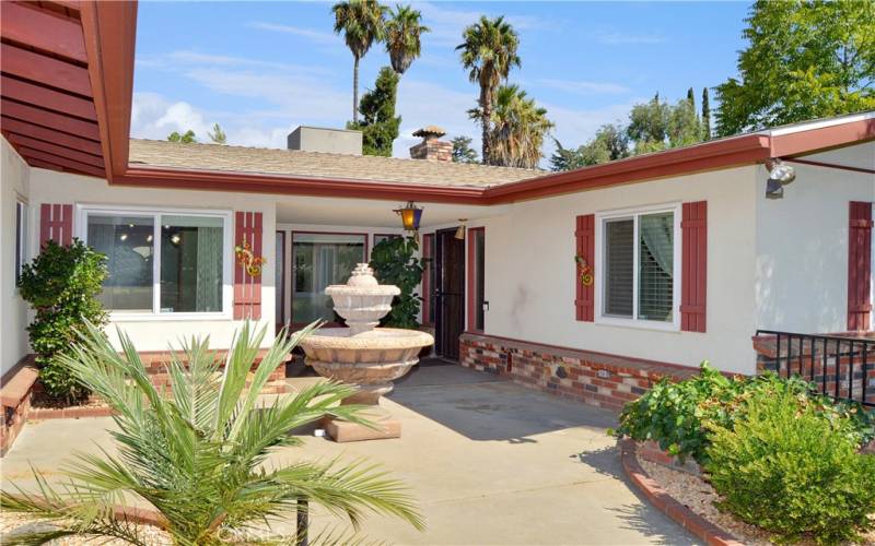 The courtyard has a sunny section out front with a covered porch at the entry