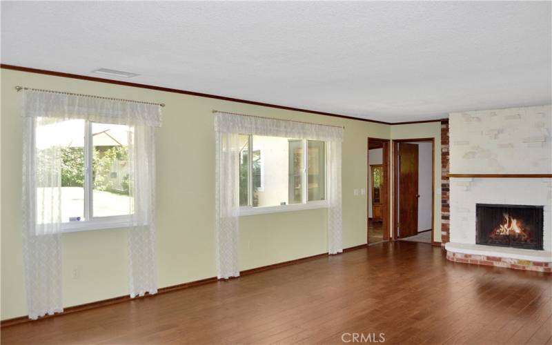 Gorgeous wood flooring, picture windows, and an impressive brick fireplace create a big, beautiful living room