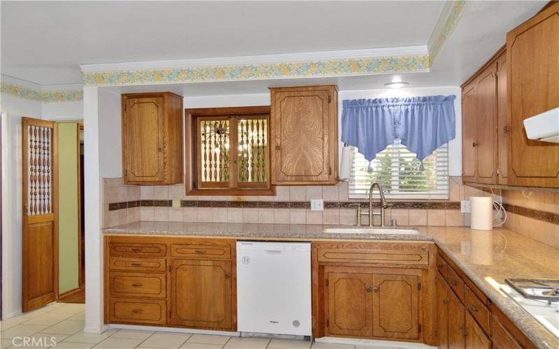 Expansive kitchen with abundant cabinet space, granite counter tops, tile flooring, and refrigerator included