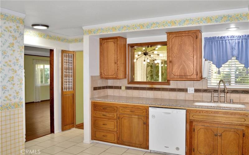 Expansive kitchen with abundant cabinet space, granite counter tops, tile flooring, and refrigerator included