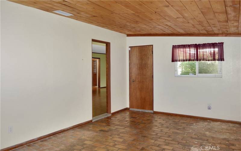 The cozy family room offers backyard views and has a charming tongue and groove ceiling