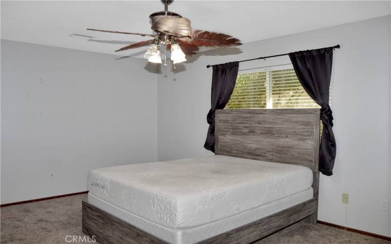 The 2nd bedroom is quite spacious, has newer carpet, a ceiling fan, and two entries - one to the hall and 2nd bath and the other to the corner of the living room where it meets the family room