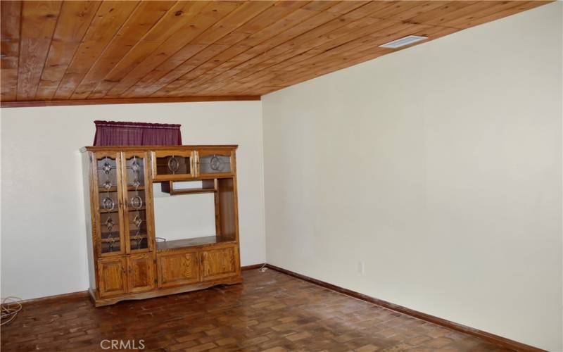 The cozy family room offers backyard views and has a charming tongue and groove ceiling