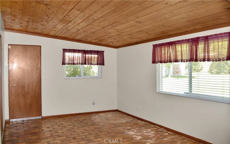 The cozy family room offers backyard views and has a charming tongue and groove ceiling