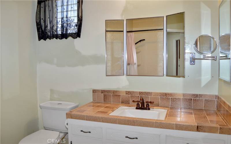 Now back to the main bedroom's en suite bath. It is accessible from the main suite and the laundry room and has a good-sized vanity, tri-fold mirror, and a tub/shower combo. It needs a paint touch up, so imagine what color you'll make it once it's yours!