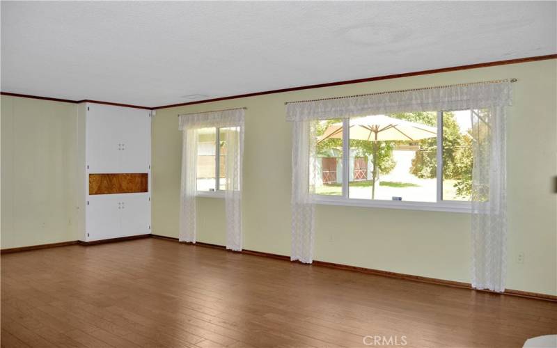 Gorgeous wood flooring, picture windows, and an impressive brick fireplace create a big, beautiful living room