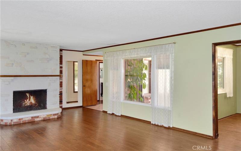 Gorgeous wood flooring, picture windows, and an impressive brick fireplace create a big, beautiful living room