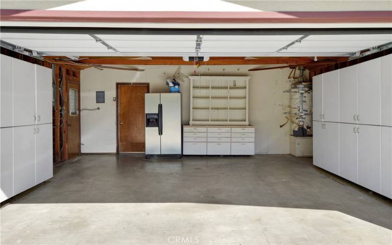 2-Car garage with storage cabinets, two doors to the outside, and access directly into the house as well