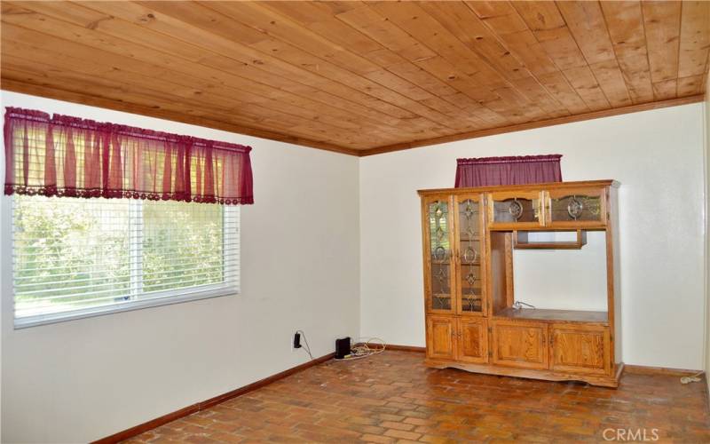 The cozy family room offers backyard views and has a charming tongue and groove ceiling