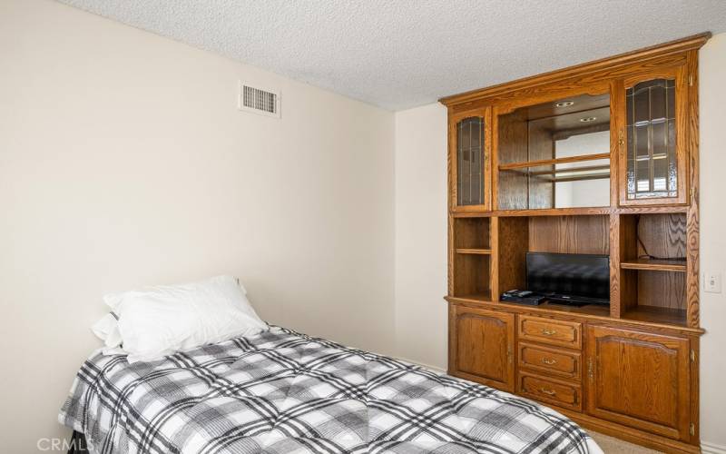 Cozy and bright bedroom 3 with built-in shelving and ample natural light