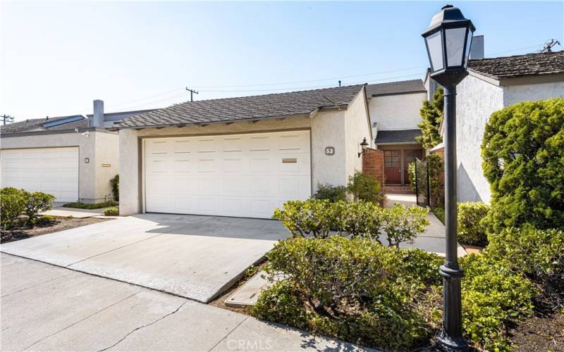 Attached two-car garage with ample driveway parking and manicured landscaping